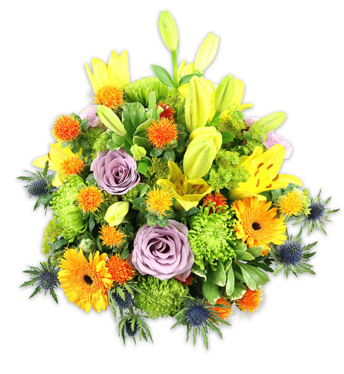 This abundant, mounded bouquet sits against a pure white background, lit so the colours read cleanly and the textures are immediately apparent. Dominant yellow Asiatic lilies reach upward, some wide open with speckled petals and visible stamens, others as tapered buds that add vertical movement and promise. Interwoven are large orange Gerbera daisies whose flat, radiating petals and dark centers create cheerful focal points, while delicate lavender-purple roses provide a softer, more intimate centre with their tightly coiled petals and gentle floral perfume. A generous scattering of lime-green button chrysanthemums or cushion blooms fills negative space with ruffled, tactile volume, and small spherical orange and yellow accent blooms-think Billy-button or tiny thistle-like spheres-introduce lively punctuation marks across the design. Cool-toned blue-grey Eryngium thistles push through at the base and flanks, their spiky, architectural forms offering a dramatic, textural counterpoint to the rounder flowers. Layered foliage, from broad lily leaves to glossy filler greens, frames and supports each bloom, lending depth and a fresh green scent that ties the palette together. The arrangement conveys warmth, optimism, and careful craftsmanship, equally suited to a joyful celebration, a thoughtful thank-you, or a comforting display at a remembrance. Crafted with an eye for seasonal balance and streetwise sensibility, it evokes local corners of Merton - perhaps a bright focal piece in a cafe near Merton Abbey Mills or a welcoming bouquet placed on a mantel in Wimbledon Village.
